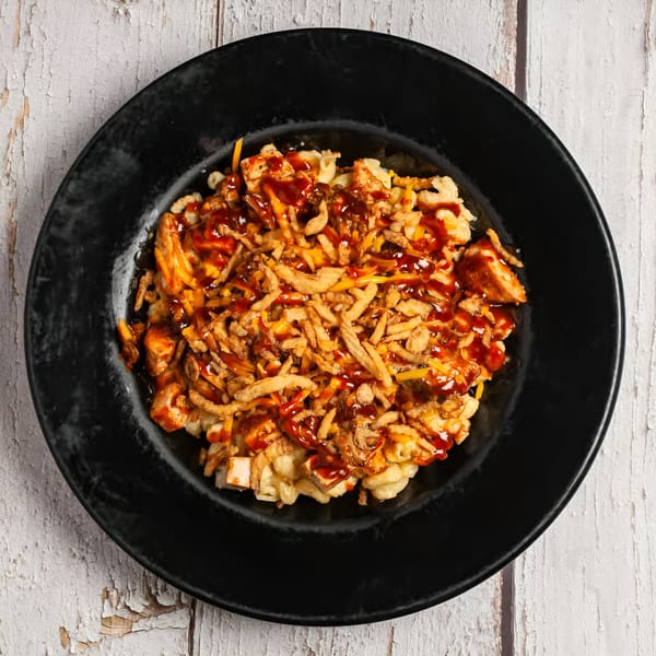 True Grit American Bistro's BBQ mac and cheese, topped with crispy fried onions and chicken.