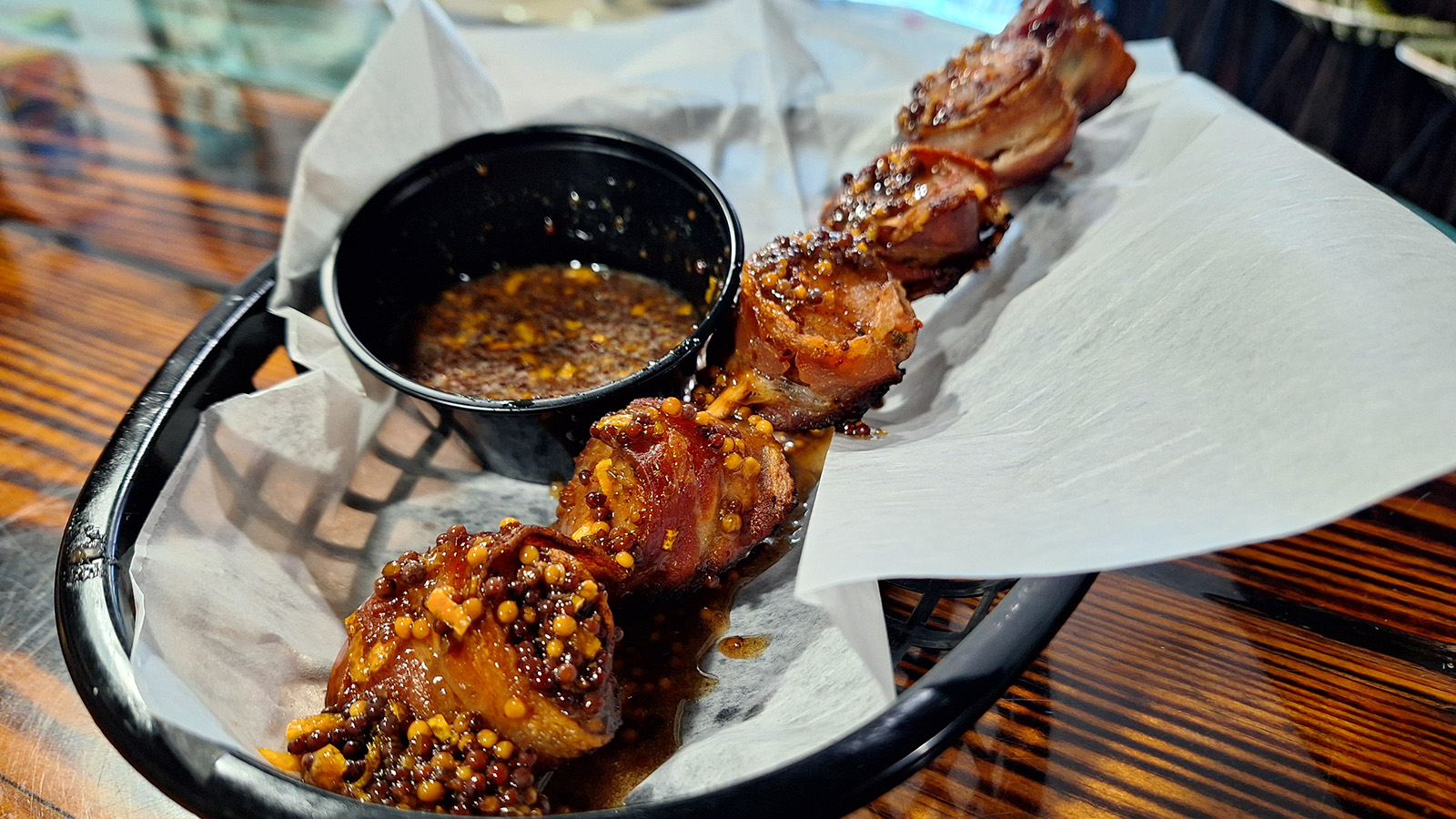 Bacon-wrapped sausage bites with black garlic honey glaze at True Grit American Bistro.